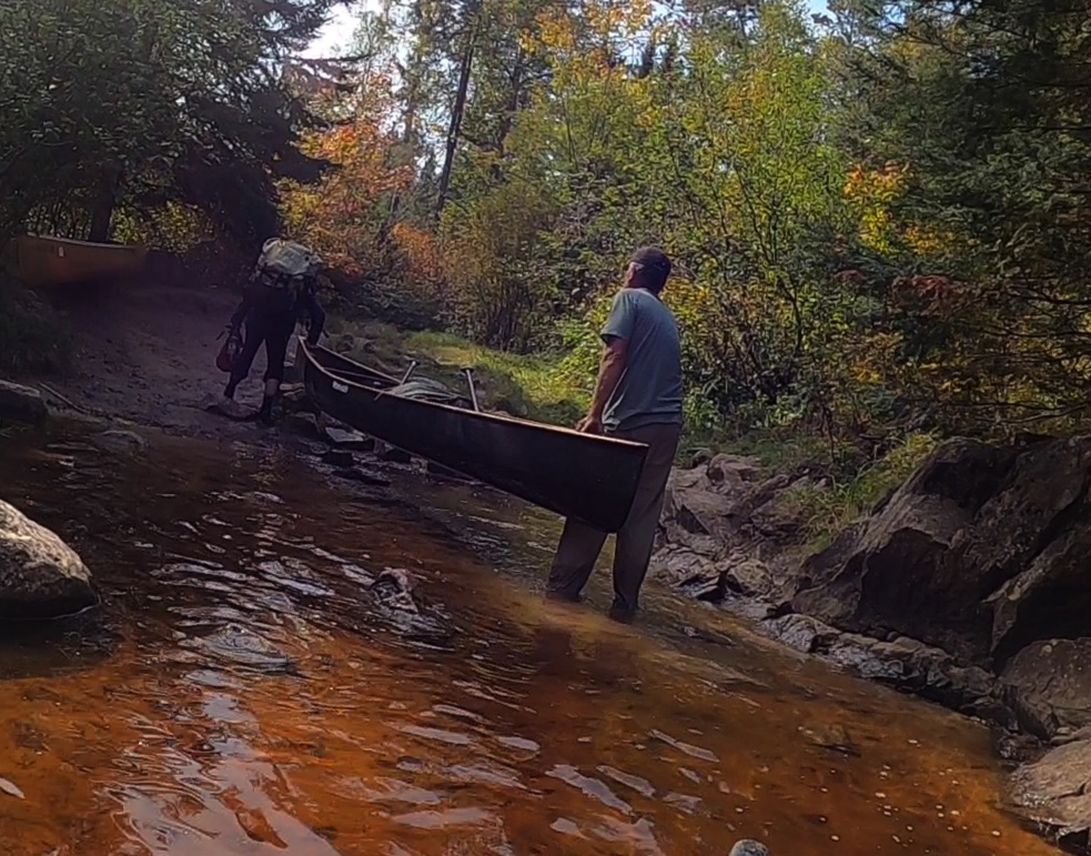 Matt & Cathy move their canoe to better loading area for portage
