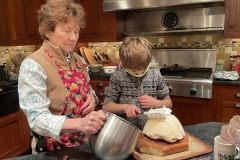 Jude spreads whipped cream on the baked alaska as Grandma observes