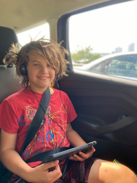Sam, traveling with headphones and iPad