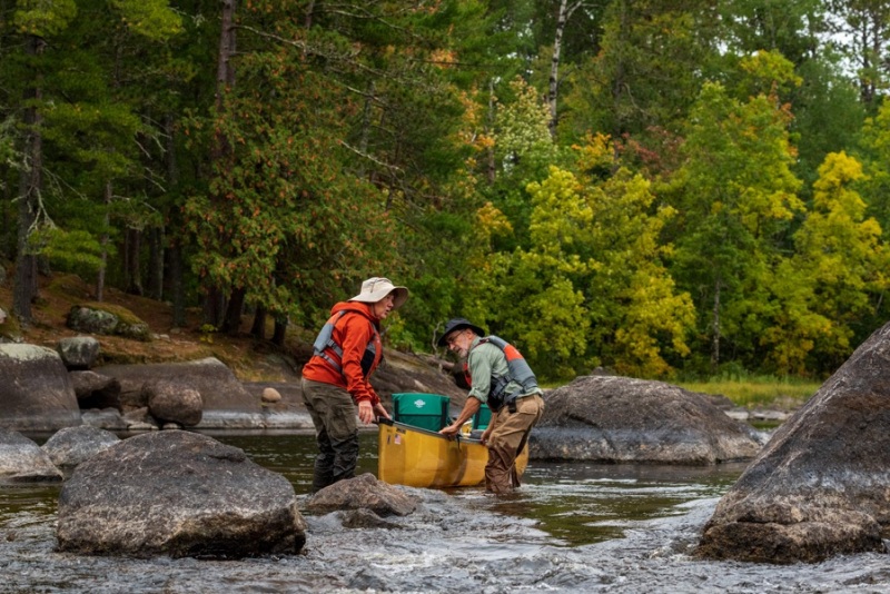 Lining their canoe against the current in MN. Photo by Cecilia Clark