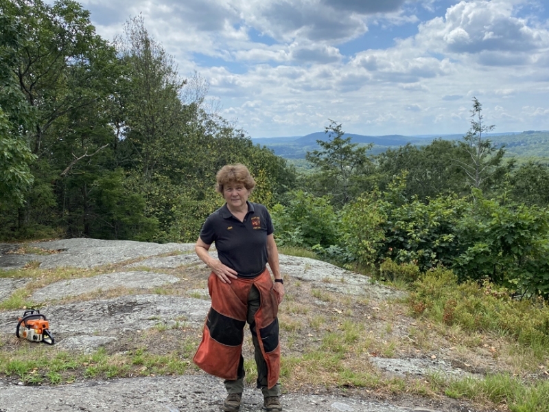 On Prospect Mountain with chaps and saw