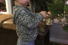 Luca places an ornament on their tree