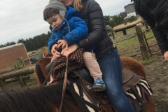Sara guides Luca on his first horseback ride.